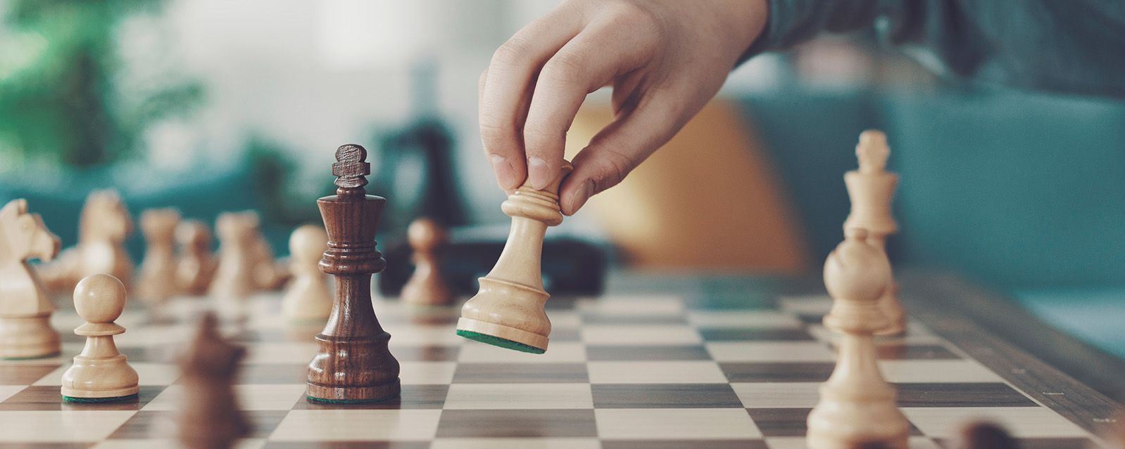 close up of child’s hand moving a chess piece on a chess board