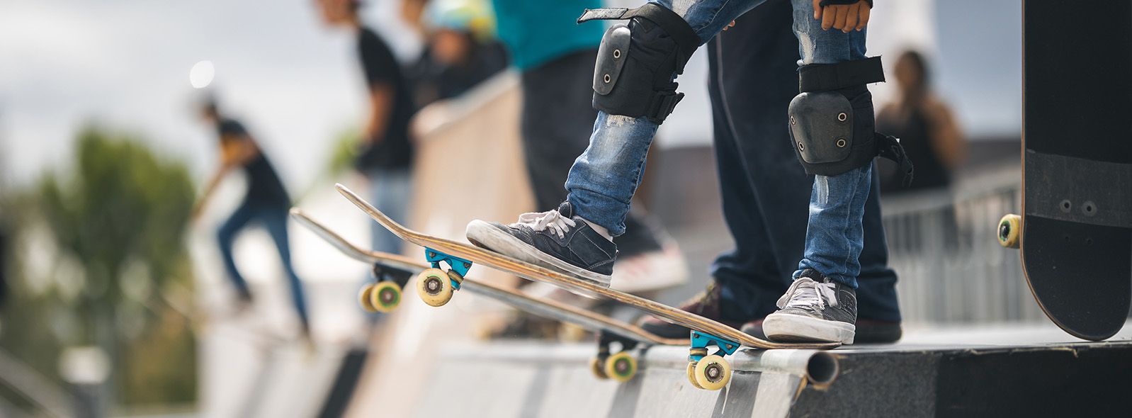 close up of kids’ feet on skate boards about to go down ramp