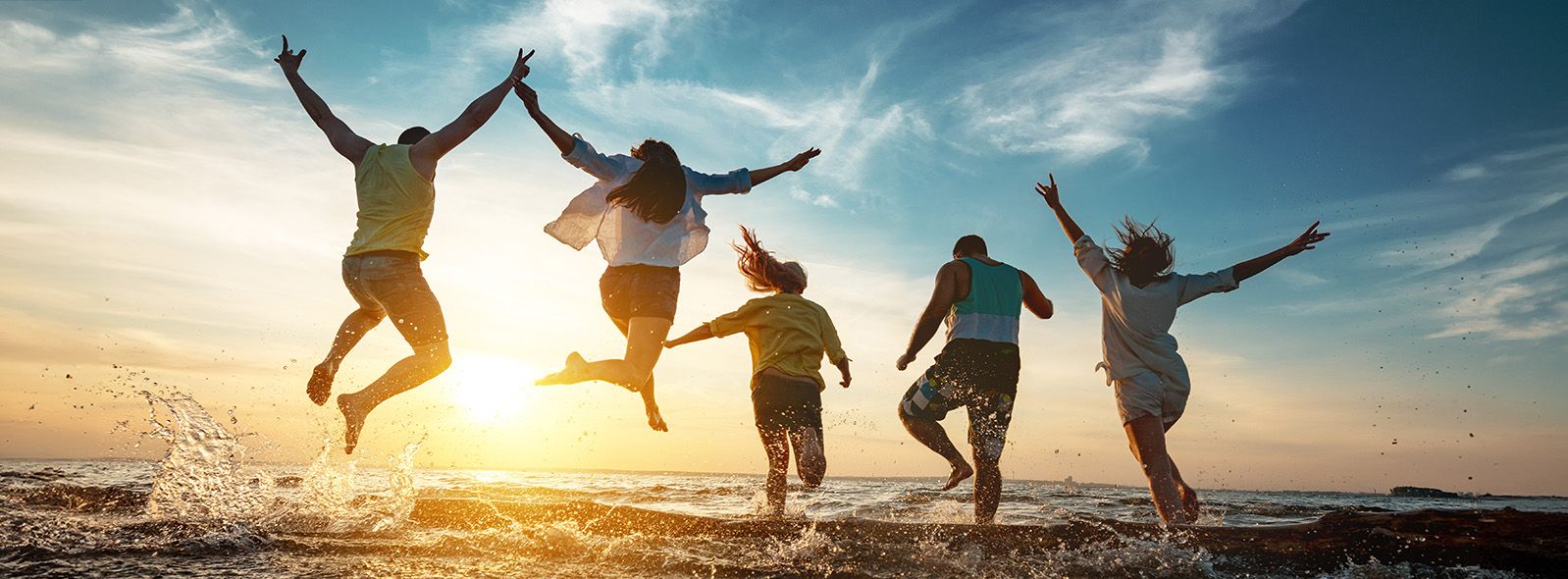 young people at beach running through water